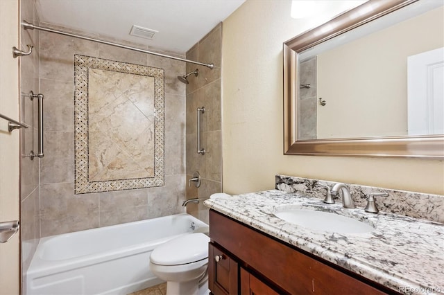 full bathroom featuring tiled shower / bath, vanity, and toilet