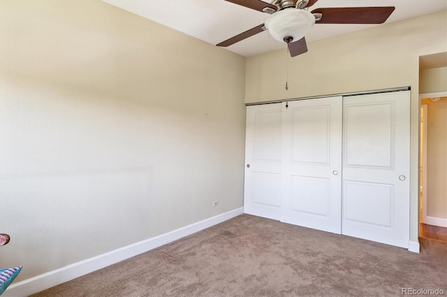 unfurnished bedroom with carpet, a closet, and ceiling fan