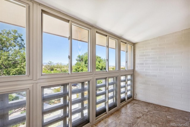 unfurnished sunroom featuring vaulted ceiling