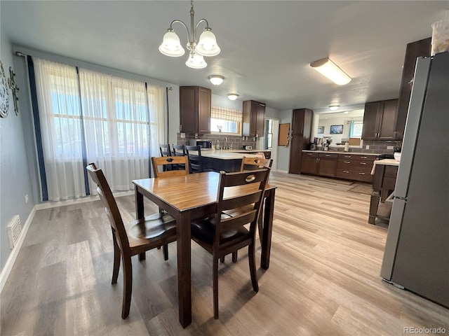 14 W 3rd St, Flagler, CO 80815 - dining area featuring light wood-style floors, a chandelier, plenty of natural light, and baseboards