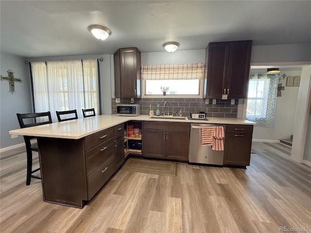 14 W 3rd St, Flagler, CO 80815 - kitchen with appliances with stainless steel finishes, a peninsula, a breakfast bar area, a sink, and light countertops