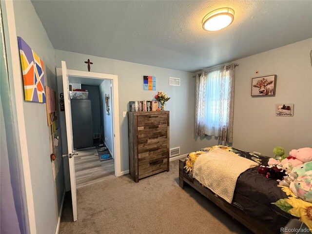 14 W 3rd St, Flagler, CO 80815 - bedroom featuring light carpet, a textured ceiling, and baseboards