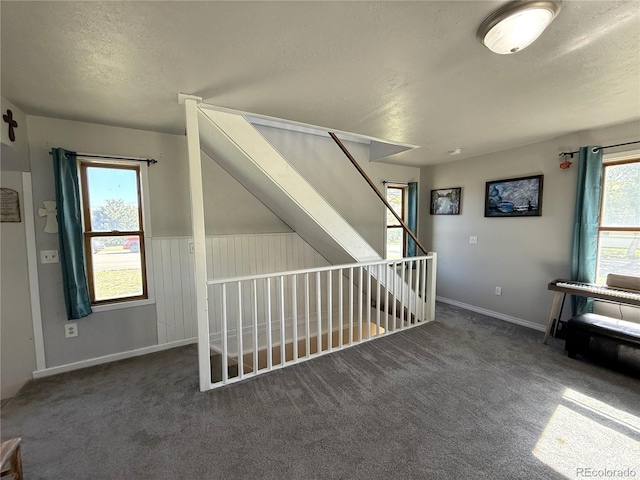 14 W 3rd St, Flagler, CO 80815 - additional living space featuring a textured ceiling, carpet flooring, and baseboards