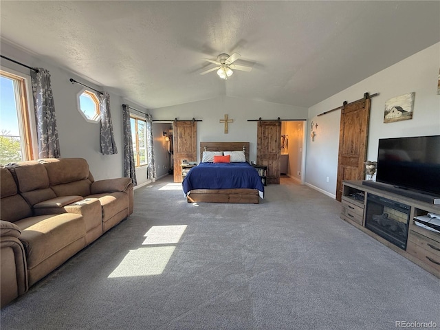 14 W 3rd St, Flagler, CO 80815 - bedroom with a barn door, lofted ceiling, carpet flooring, baseboards, and ceiling fan