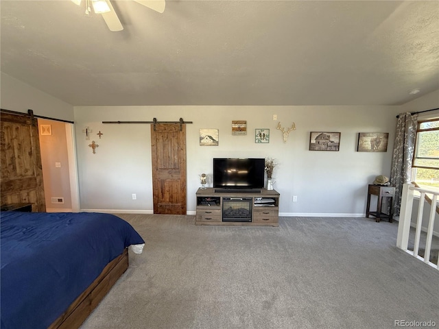 14 W 3rd St, Flagler, CO 80815 - carpeted bedroom featuring a barn door, baseboards, and a ceiling fan
