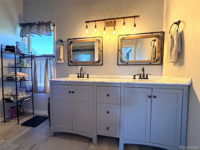 14 W 3rd St, Flagler, CO 80815 - bathroom with wood finished floors, double vanity, and baseboards
