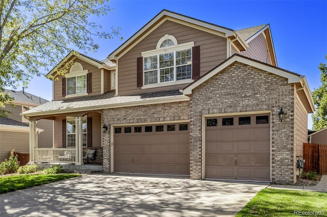 traditional-style house with covered porch, an attached garage, fence, brick siding, and driveway