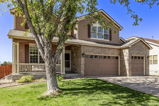 traditional-style home with brick siding, covered porch, a garage, concrete driveway, and a front lawn