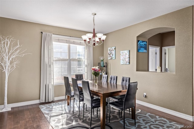 dining space with a notable chandelier and dark wood-type flooring