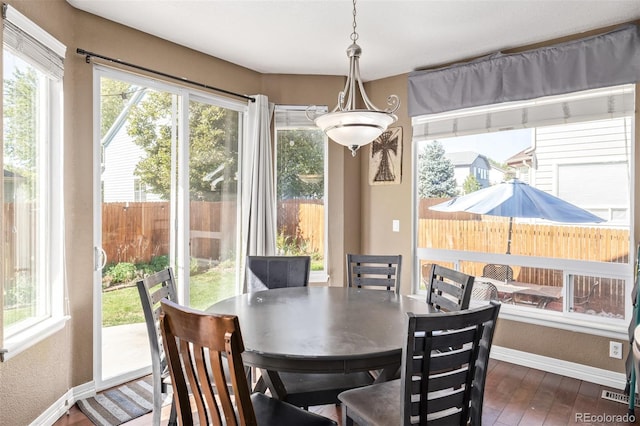 dining area with plenty of natural light, visible vents, baseboards, and hardwood / wood-style floors