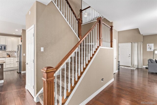 stairs featuring baseboards and hardwood / wood-style floors