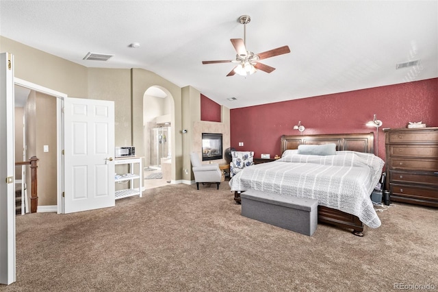 carpeted bedroom with connected bathroom, a ceiling fan, visible vents, and lofted ceiling