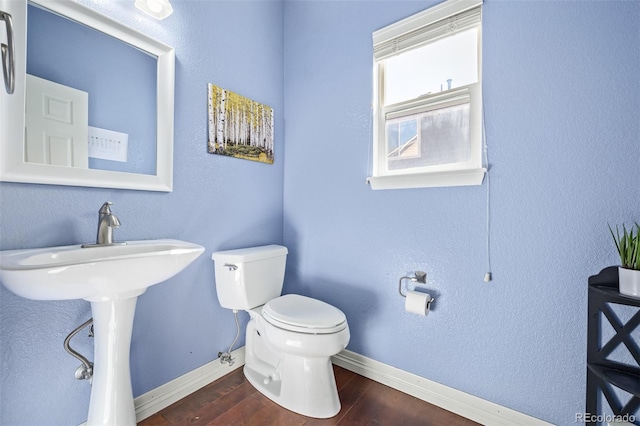 bathroom with wood-type flooring, toilet, and sink