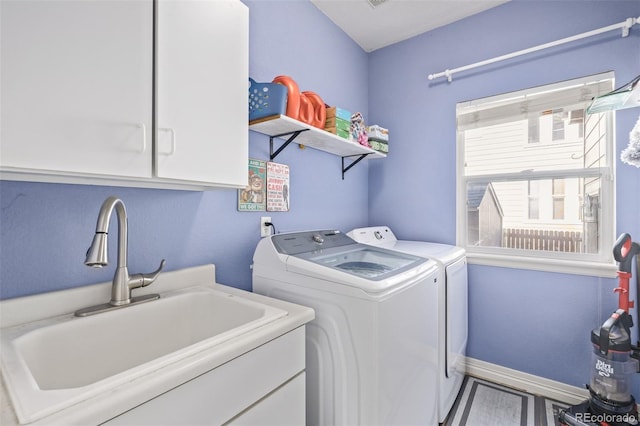 laundry room with separate washer and dryer, cabinet space, baseboards, and a sink