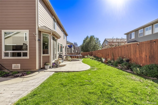 view of yard with a trampoline, a patio area, and a fenced backyard