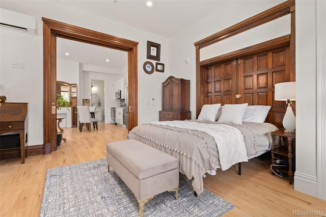 bedroom with recessed lighting, light wood-style floors, and a wall mounted air conditioner