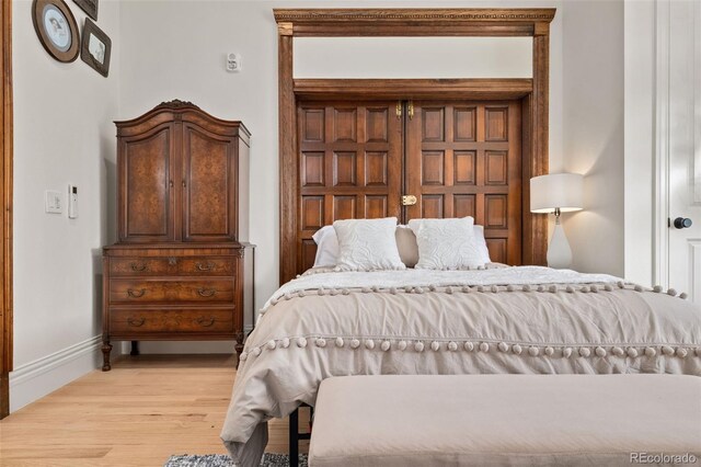 bedroom with light wood-type flooring and baseboards