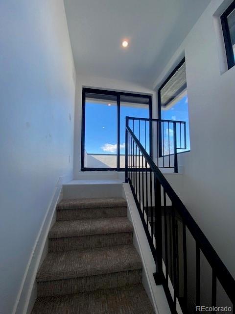 stairs with baseboards and recessed lighting