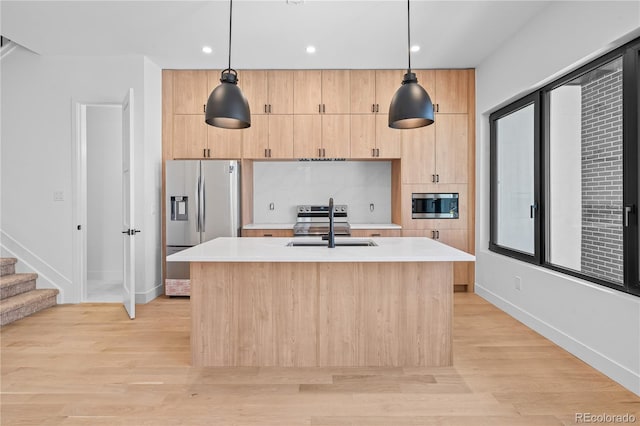 kitchen with light countertops, appliances with stainless steel finishes, and decorative light fixtures