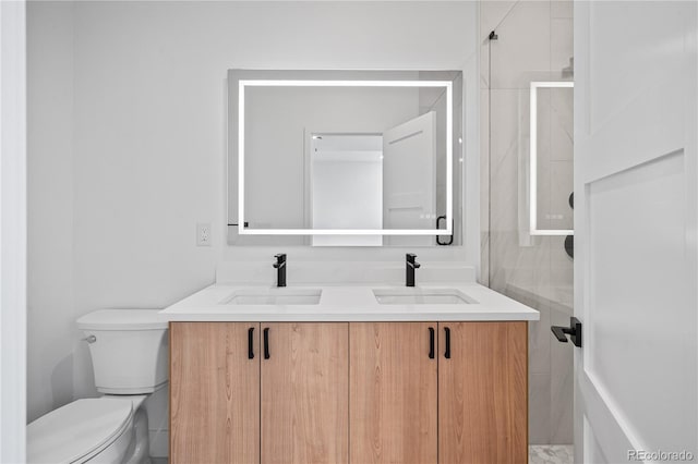 full bath featuring double vanity, a sink, and toilet