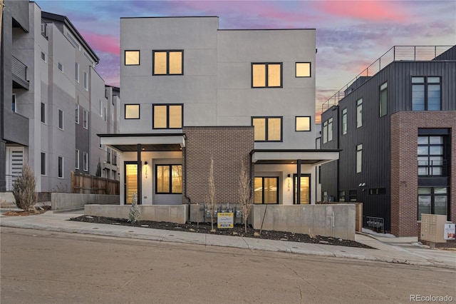 back of house with a fenced front yard and stucco siding