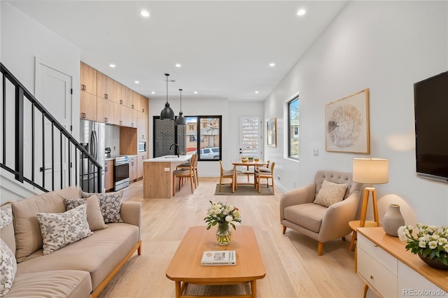 living area with stairs, light wood-type flooring, baseboards, and recessed lighting