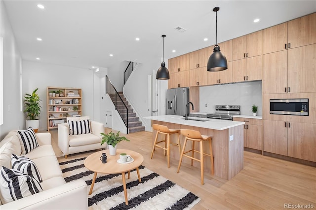 living room with light wood-style floors, recessed lighting, visible vents, and stairway