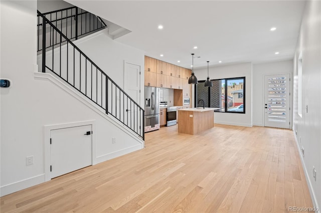 unfurnished living room with recessed lighting, a sink, baseboards, stairs, and light wood finished floors