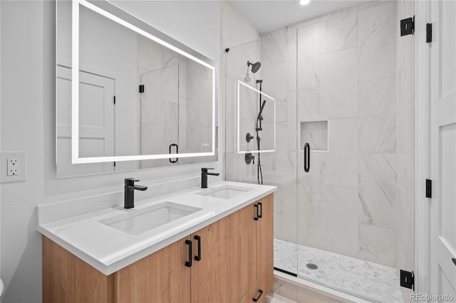 full bath featuring a sink, a marble finish shower, and double vanity