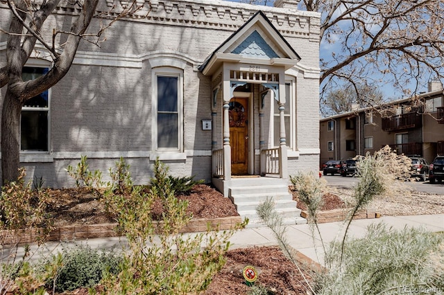 exterior space featuring a chimney and brick siding