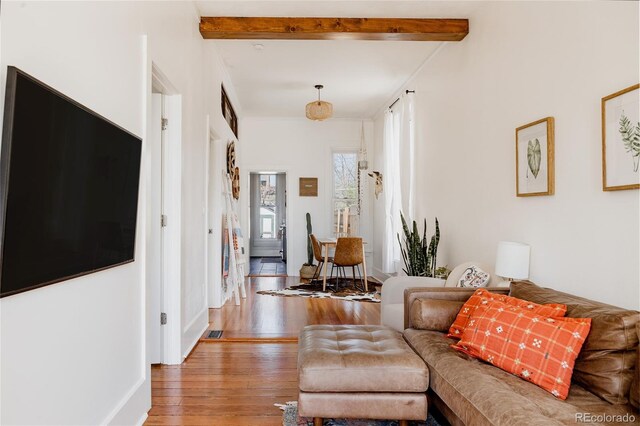 living room with beamed ceiling, wood-type flooring, and visible vents