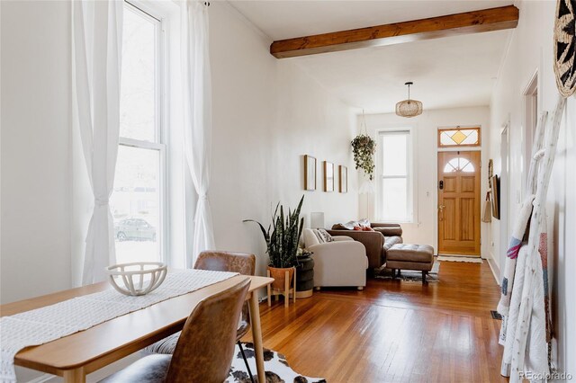 dining space featuring beam ceiling and hardwood / wood-style floors