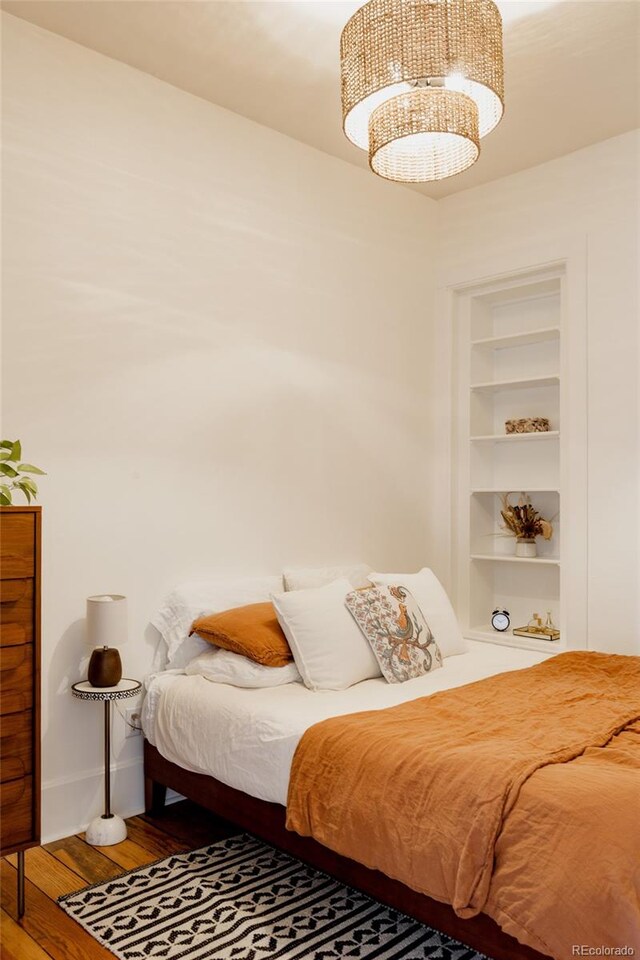 bedroom featuring baseboards and wood finished floors