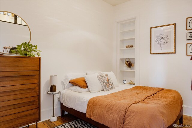 bedroom featuring baseboards and wood finished floors