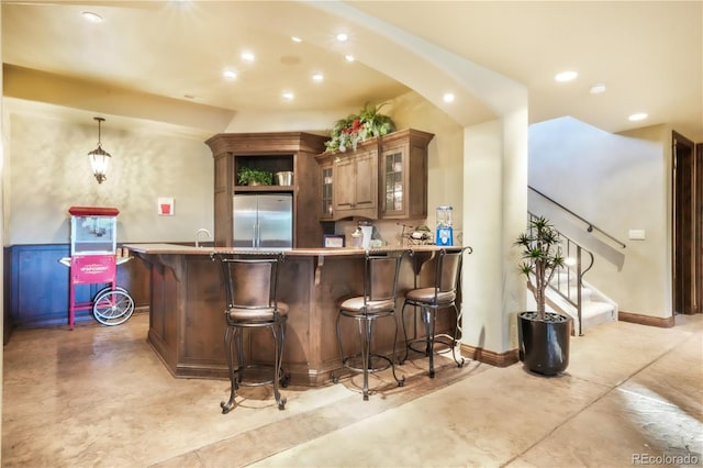 17540 Pond View Pl, Colorado Springs, CO 80908 - indoor wet bar with stainless steel built in fridge, recessed lighting, concrete floors, stairway, and baseboards