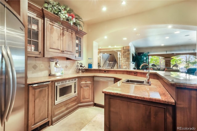 17540 Pond View Pl, Colorado Springs, CO 80908 - kitchen featuring stainless steel appliances, a sink, recessed lighting, tasteful backsplash, and light stone countertops