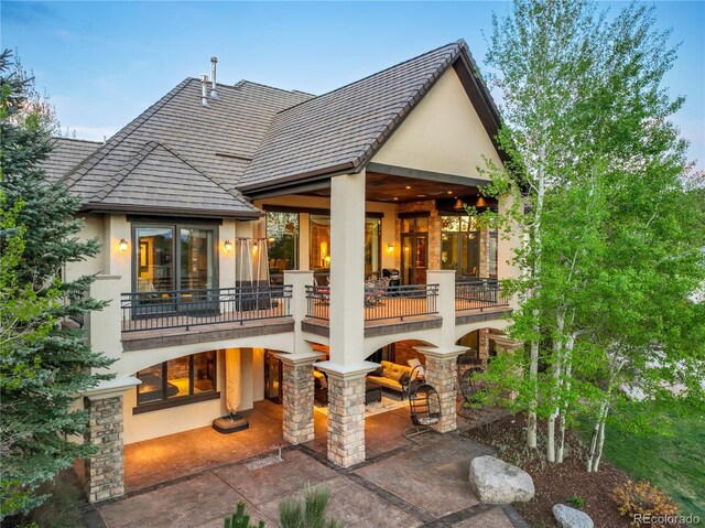 17540 Pond View Pl, Colorado Springs, CO 80908 - rear view of house featuring stucco siding, a balcony, and a patio
