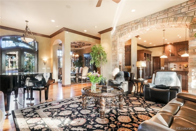 17540 Pond View Pl, Colorado Springs, CO 80908 - living room featuring arched walkways, ornate columns, crown molding, wood finished floors, and ceiling fan