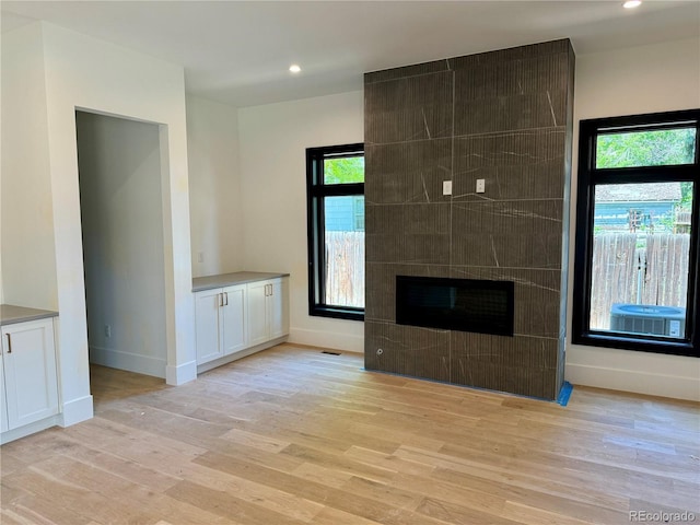 2442 S Saint Paul St, Denver, CO 80210 - unfurnished living room with light wood-style floors, recessed lighting, and a tiled fireplace