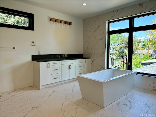 2442 S Saint Paul St, Denver, CO 80210 - bathroom with marble finish floors, vanity, a freestanding bath, and recessed lighting