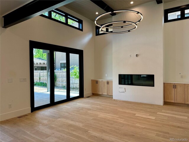 2442 S Saint Paul St, Denver, CO 80210 - unfurnished living room featuring high vaulted ceiling, a chandelier, plenty of natural light, light wood finished floors, and recessed lighting