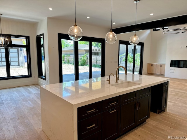 2442 S Saint Paul St, Denver, CO 80210 - kitchen with open floor plan, light wood-style floors, light stone countertops, decorative light fixtures, and recessed lighting