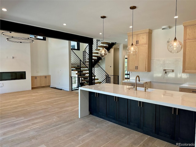 2442 S Saint Paul St, Denver, CO 80210 - kitchen featuring light brown cabinetry, light wood finished floors, plenty of natural light, hanging light fixtures, and recessed lighting