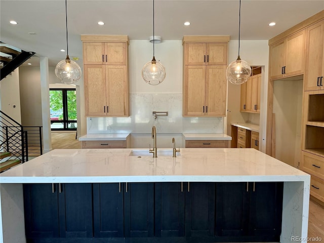 2442 S Saint Paul St, Denver, CO 80210 - kitchen with light brown cabinets, a large island, recessed lighting, light stone countertops, and light wood-style floors