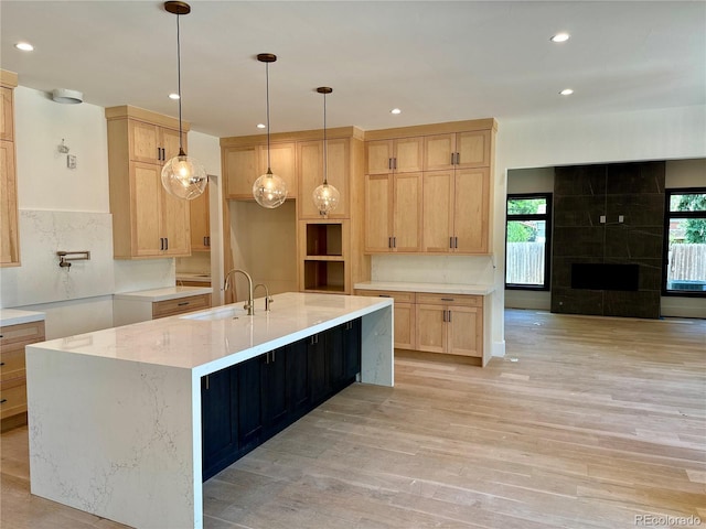 2442 S Saint Paul St, Denver, CO 80210 - kitchen with light wood finished floors, light brown cabinetry, a spacious island, recessed lighting, and light stone counters