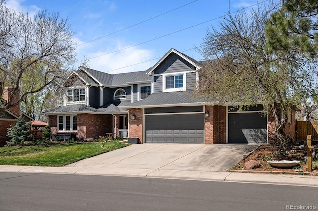 view of front of house with fence, a front lawn, concrete driveway, brick siding, and a garage