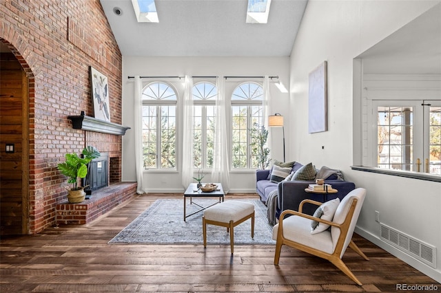 interior space with a healthy amount of sunlight, wood finished floors, visible vents, and a skylight
