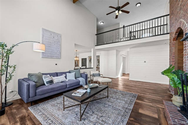 living area featuring wood finished floors, baseboards, high vaulted ceiling, and ceiling fan
