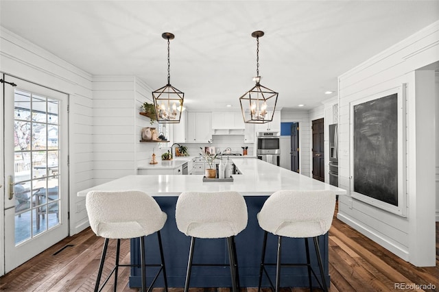 kitchen featuring white cabinets, open shelves, dark wood-type flooring, a chandelier, and appliances with stainless steel finishes