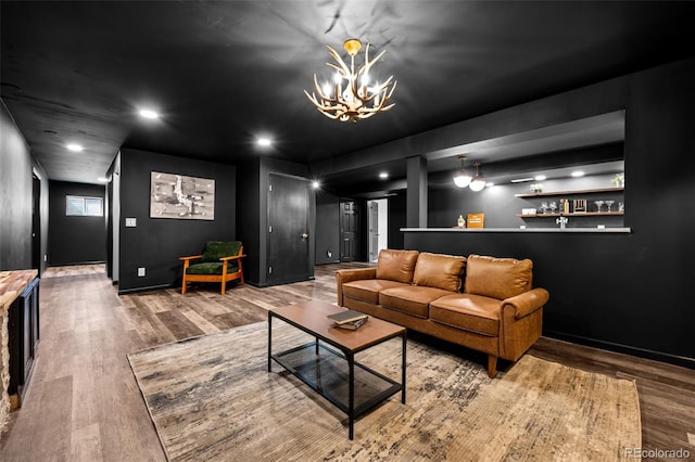 living area featuring baseboards, a notable chandelier, wood finished floors, and recessed lighting